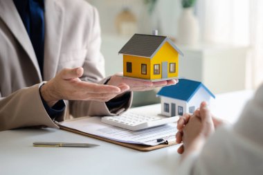 Real estate agents explain models of housing estates in projects to elaborate to clients, explaining and presenting information about homes and purchasing loans. Real estate trading concept.