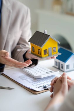 Emlakçılar, konut modellerini müşterilere ayrıntılı bir şekilde anlatma, evler ve satın alma kredileri hakkında bilgi verme ve sunma konularında açıklar. Gayrimenkul ticareti.