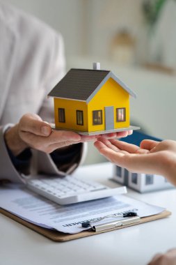 Emlakçılar, konut modellerini müşterilere ayrıntılı bir şekilde anlatma, evler ve satın alma kredileri hakkında bilgi verme ve sunma konularında açıklar. Gayrimenkul ticareti.