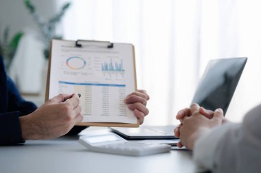 Grup iş adamları birlikte beyin fırtınası yapıyorlar ve finans departmanının özetlediği finansal belgeleri gözden geçiriyorlar. Onlar iş ortakları. İş yönetimi kavramı.