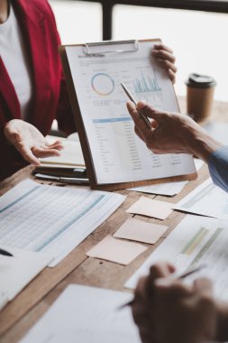 The sales department is having a monthly summary meeting to bring it to the department manager, they are verifying the correctness of the documents that are prepared before bringing in to the manager.