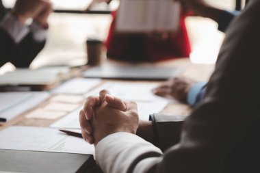 The sales department is having a monthly summary meeting to bring it to the department manager, they are verifying the correctness of the documents that are prepared before bringing in to the manager.