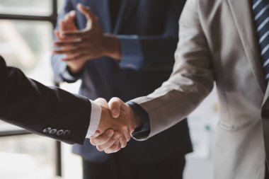 Yakın plan iki iş adamı el ele tutuşuyor, iki işadamı iş konusunda hemfikir ve başarılı bir pazarlıktan sonra el sıkışıyor. El sıkışmak Batının selamlaması ya da kutlamasıdır..