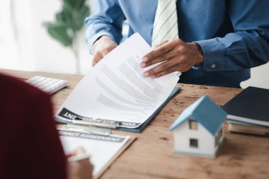 Ev satış temsilcileri ve satış temsilcileri projedeki evleri görmek isteyen müşterilere projede konut detaylarını tavsiye ediyorlar. Gayrimenkul ticareti.