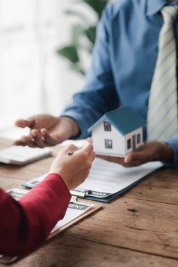 Ev satış temsilcileri ve satış temsilcileri projedeki evleri görmek isteyen müşterilere projede konut detaylarını tavsiye ediyorlar. Gayrimenkul ticareti.