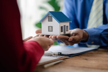 Ev satış temsilcileri ve satış temsilcileri projedeki evleri görmek isteyen müşterilere projede konut detaylarını tavsiye ediyorlar. Gayrimenkul ticareti.