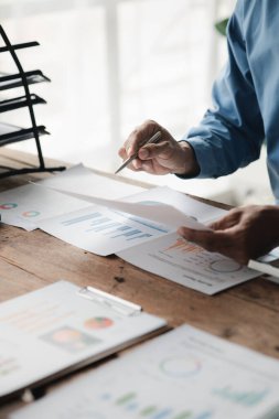 İşadamı şirketinde özel bir ofiste oturuyor ve şirketin mali belgelerini inceliyor, üst düzey yönetim finansal bilgilerin doğruluğunu kontrol ediyor. Mali yönetim.