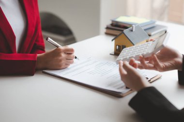 Ev satış temsilcileri ve satış temsilcileri projedeki evleri görmek isteyen müşterilere projede konut detaylarını tavsiye ediyorlar. Gayrimenkul ticareti.