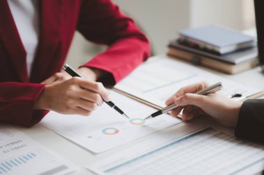 Two businessmen are brainstorming together and reviewing the company financial documents that the finance department has summarized, they are business partners. Business administration concept.