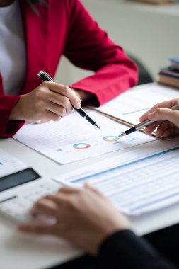 Two businessmen are brainstorming together and reviewing the company financial documents that the finance department has summarized, they are business partners. Business administration concept.