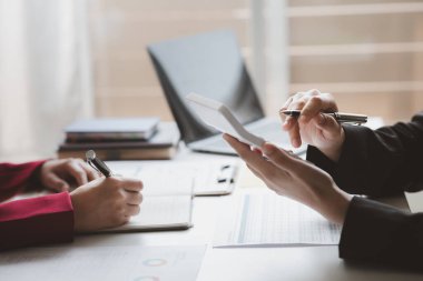 Two businessmen are brainstorming together and reviewing the company financial documents that the finance department has summarized, they are business partners. Business administration concept.