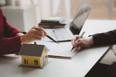 Ev satış temsilcileri ve satış temsilcileri projedeki evleri görmek isteyen müşterilere projede konut detaylarını tavsiye ediyorlar. Gayrimenkul ticareti.