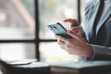 İşe ara verdiğinde cep telefonuyla oynayan güzel bir Asyalı kadın. Yeni başlayan bir şirketin pazarlama müdürü, kadın lider, yönetici ve CEO 'su. Kadın Liderlik Konsepti.