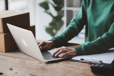 Bir kişi dizüstü bilgisayar kullanıyor. İşletme sahibi bir internet mağazası açıyor, müşterilerin siparişlerini kontrol ediyor, bir kurye şirketi aracılığıyla mal gönderiyor, online bir iş kurma kavramı.