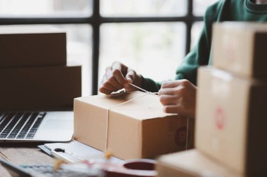 Müşteri kutusuna paket bağlayan bir kadın, çevrimiçi bir mağazası var, özel bir nakliye şirketi aracılığıyla paketleyip gönderiyor. Çevrimiçi satış ve online alışveriş kavramları.