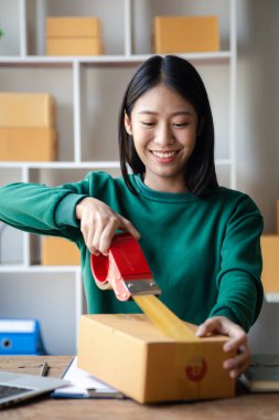 Bir kişi siparişlere göre paket kutuları topluyor, çevrimiçi bir mağazası var, özel bir nakliye şirketi aracılığıyla paketleyip gönderiyor. Çevrimiçi satış ve online alışveriş kavramları.