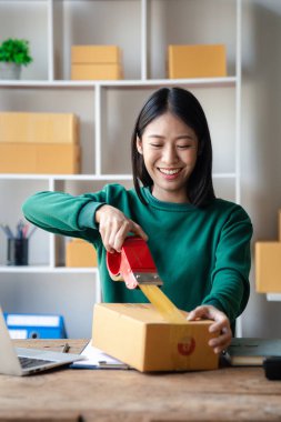 Bir kişi siparişlere göre paket kutuları topluyor, çevrimiçi bir mağazası var, özel bir nakliye şirketi aracılığıyla paketleyip gönderiyor. Çevrimiçi satış ve online alışveriş kavramları.