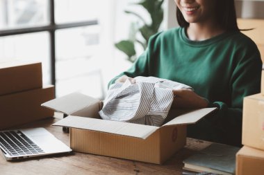 Bir kişi siparişlere göre paket kutuları topluyor, çevrimiçi bir mağazası var, özel bir nakliye şirketi aracılığıyla paketleyip gönderiyor. Çevrimiçi satış ve online alışveriş kavramları.