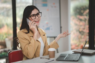 Telefonda konuşan Asyalı bir kadın, bir girişim şirketinde satış elemanı, ürün ve promosyon satmak için müşterileri arıyor. Telefon kanalları aracılığıyla ürün satma kavramı.