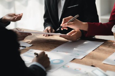 Businessman is reviewing monthly sales documents for analysis and marketing plans for more sales growth, they are the founders of young companies co-founding startups. Sales management concept.