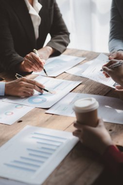 Businessman is reviewing monthly sales documents for analysis and marketing plans for more sales growth, they are the founders of young companies co-founding startups. Sales management concept.