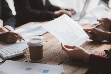 Businessman is reviewing monthly sales documents for analysis and marketing plans for more sales growth, they are the founders of young companies co-founding startups. Sales management concept.