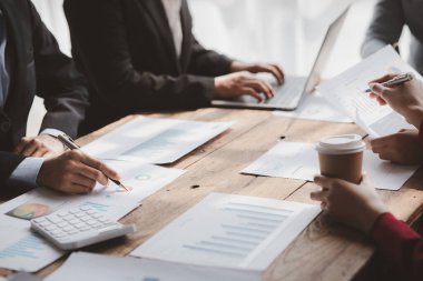 Businessman is reviewing monthly sales documents for analysis and marketing plans for more sales growth, they are the founders of young companies co-founding startups. Sales management concept.