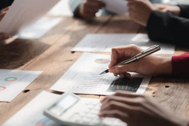 Businessman is reviewing monthly sales documents for analysis and marketing plans for more sales growth, they are the founders of young companies co-founding startups. Sales management concept.