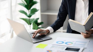 A business women working in a private room, He is typing on a laptop keyboard, He uses a messenger to chat with a partner. Concept of using technology in communication.