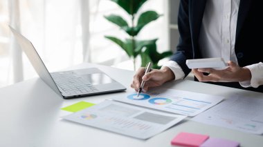 Bir kadın finansör şirketin mali belgelerini inceliyor. Finans departmanından aylık hesap özeti. Şirketin doğruluk ve büyüme finansmanını yönetme kavramı.