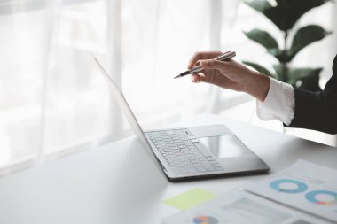 Person pointing at laptop screen, businessman sitting at company, looking at financial information on laptop summarized by the finance department. Concept of financial management.