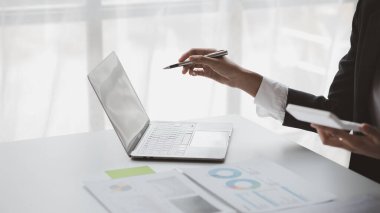 Laptop ekranını gösteren kişi, şirkette oturan iş adamı finans departmanı tarafından özetlenen dizüstü bilgisayardaki finansal bilgilere bakıyor. Mali yönetim kavramı.