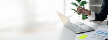 Laptop ekranını gösteren kişi, şirkette oturan iş adamı finans departmanı tarafından özetlenen dizüstü bilgisayardaki finansal bilgilere bakıyor. Mali yönetim kavramı.
