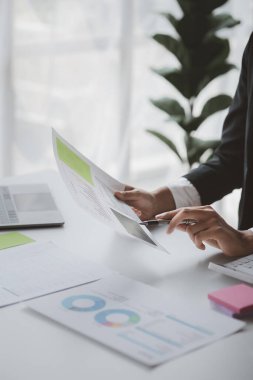 A female financier is reviewing company financial documents, monthly financial statement summary from the finance department. The concept of managing the company's finances for accuracy and growth.