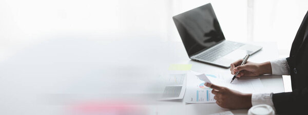 A female financier is reviewing company financial documents, monthly financial statement summary from the finance department. The concept of managing the company's finances for accuracy and growth.