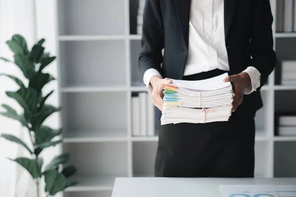 Businessman holding a lot of documents, corporate financial documents, monthly financial summary documents. Concept of document management in the organization.