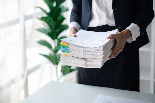 Businessman holding a lot of documents, corporate financial documents, monthly financial summary documents. Concept of document management in the organization.