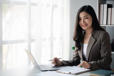 Asian women working in the office, young Asian business women as business executives, founding and running start-up executives, young female business leaders. Startup business concept.