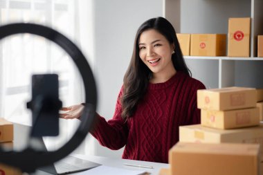 İnsanlar canlı yayında ürün satıyor, çevrimiçi ürün satıyor, çevrimiçi satış siteleri üzerinden sipariş veren müşterilerin siparişlerini paketliyorlar. Ürün çevrimiçi ve e-ticaret kavramı.