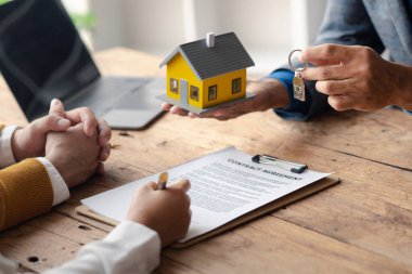 Ev satış temsilcileri ve satış temsilcileri projedeki evleri görmek isteyen müşterilere projede konut detaylarını tavsiye ediyorlar. Gayrimenkul ticareti.