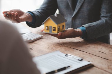 Ev satış temsilcileri ve satış temsilcileri projedeki evleri görmek isteyen müşterilere projede konut detaylarını tavsiye ediyorlar. Gayrimenkul ticareti.