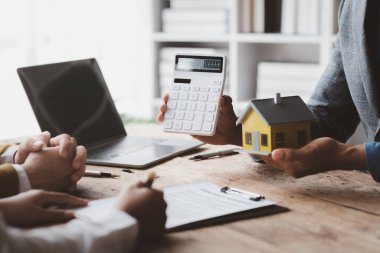 Ev satış temsilcileri ve satış temsilcileri projedeki evleri görmek isteyen müşterilere projede konut detaylarını tavsiye ediyorlar. Gayrimenkul ticareti.