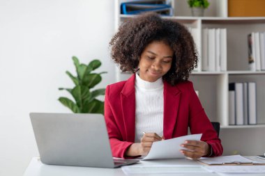 Genç bir Amerikalı kadın yeni başlayan bir iş kadınıdır, ofiste oturur, genç bir jenerasyonun işlerini yönetir ve yönetir. Girişim işletme yönetimi kavramı.