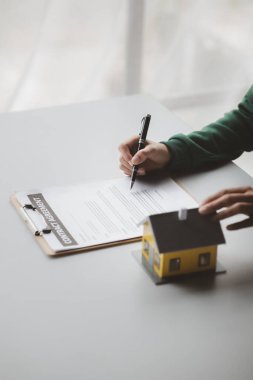 The salesperson of the housing estate in the project is preparing and verifying the contract of sale for the customer who will enter the contract. Concept of selling housing estates and real estate.