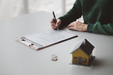 The salesperson of the housing estate in the project is preparing and verifying the contract of sale for the customer who will enter the contract. Concept of selling housing estates and real estate.
