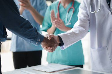 Hastanedeki konferans odası, bir grup doktorun el sıkışma toplantısına katılması, yönetici doktorların ve şeflerin ilaç satıcılarıyla buluşması. Doktor toplantısı konsepti.