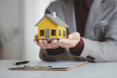 Real estate agents explain models of housing estates in projects to elaborate to clients, explaining and presenting information about homes and purchasing loans. Real estate trading concept.