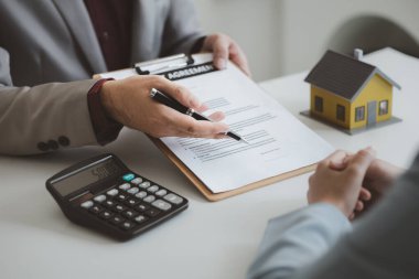 Real estate agents explain models of housing estates in projects to elaborate to clients, explaining and presenting information about homes and purchasing loans. Real estate trading concept.