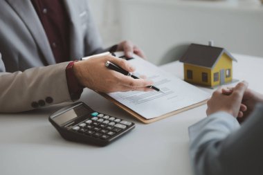 Real estate agents explain models of housing estates in projects to elaborate to clients, explaining and presenting information about homes and purchasing loans. Real estate trading concept.