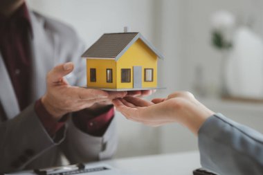 Emlakçılar, konut modellerini müşterilere ayrıntılı bir şekilde anlatma, evler ve satın alma kredileri hakkında bilgi verme ve sunma konularında açıklar. Gayrimenkul ticareti.